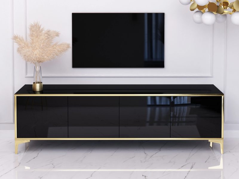 Schwarzes TV-Lowboard Monako 180cm Hochglanz mit goldenen Akzenten im Wohnzimmer mit Fernseher.