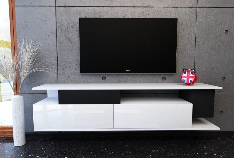TV-Lowboard Malaga 180cm Weiß Hochglanz mit schwarzen Elementen im modernen Wohnzimmer mit Wand-TV.