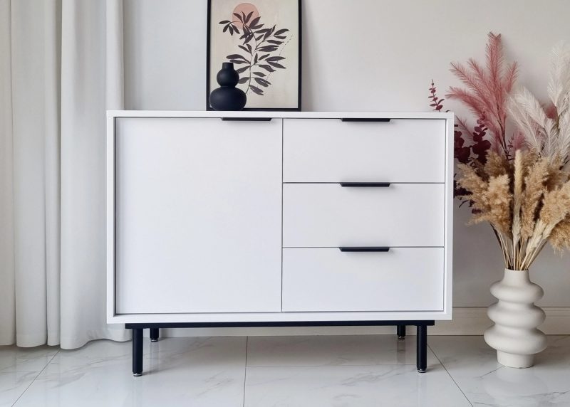 Kommode Cala 104cm Weiß Matt mit schwarzen Griffen, Frontansicht im modernen Interieur