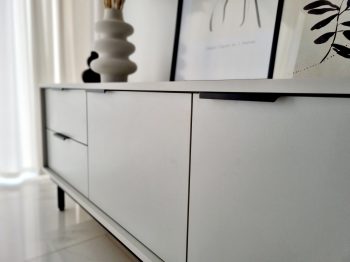 Detailansicht der Front des TV-Lowboards Cala Weiß Matt mit schwarzen Griffen