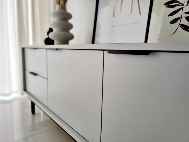 Detailansicht der Front des TV-Lowboards Cala Weiß Matt mit schwarzen Griffen