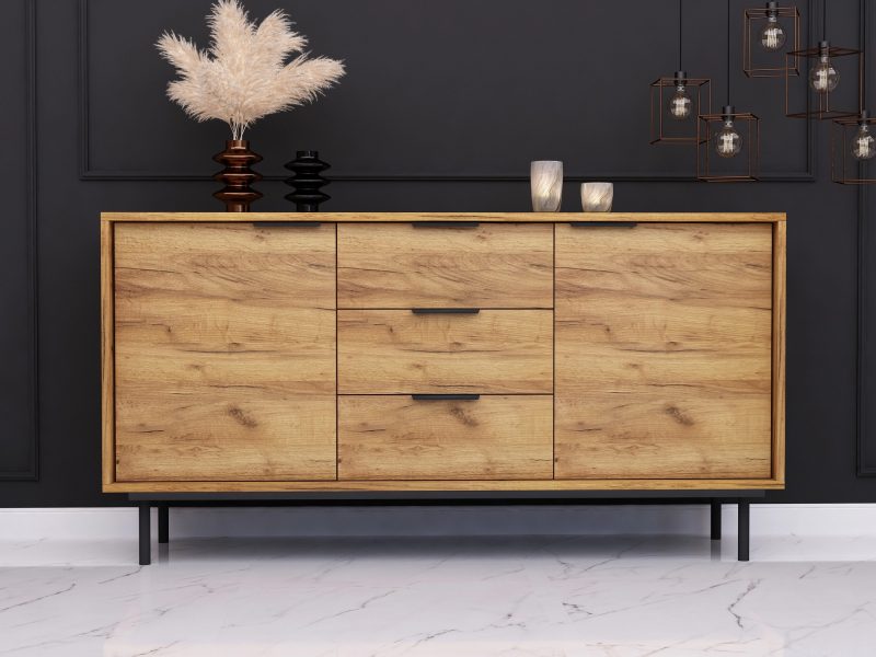 Kommode Cala 154cm in Eiche Craft Gold Matt, im modernen Wohnzimmer mit schwarzer Wand und Dekoration.