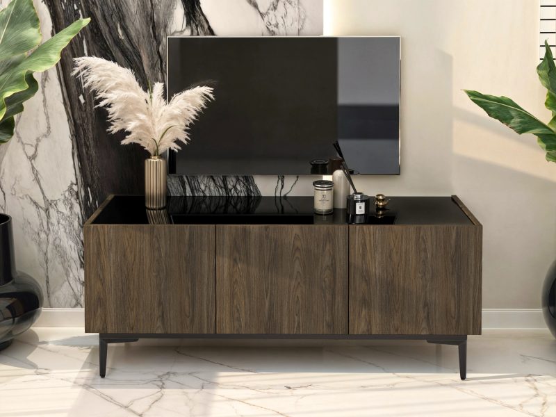 TV-Lowboard Pari 135cm im Wohnzimmer mit Fernseher und Dekoration auf schwarzer Hochglanzplatte